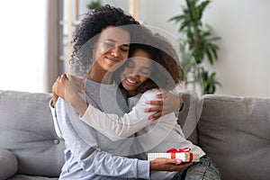 Happy mom hugging daughter thanking for present photo