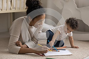 Happy African American mother drawing with toddler baby