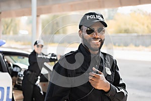 Happy african american police officer looking