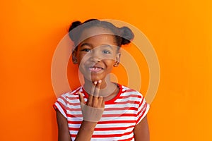 Happy african american schoolgirl going sign language with hand over orange background