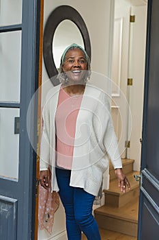 Happy african american senior woman standing in doorway and smiling