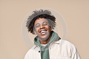 Happy African American teen boy laughing isolated on beige, close up portrait.