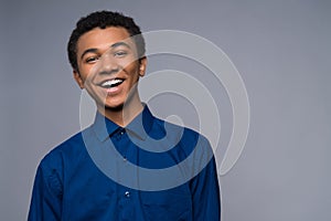 Happy African American teenager in denim shirt.