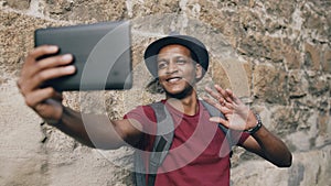 Happy african american tourist man having online video chat using tablet computer while travelling in Europe