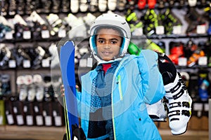 Happy African American tweenager in skiing outfit in modern store of sports equipment