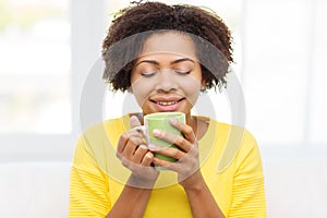 Happy african american woman drinking from tea cup