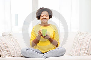 Happy african american woman drinking from tea cup