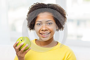 Happy african american woman with green apple
