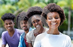 Happy african american woman with group of young adults in line