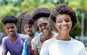 Happy african american woman with group of young adults in line photo