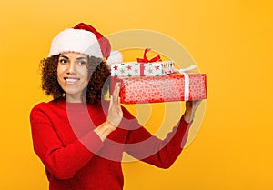 Happy African American woman holds in hands stack of christmas gifts. smiling. Xmas