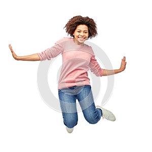Happy african american woman jumping over white