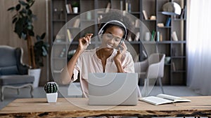 Happy African American woman listen to music in headphones