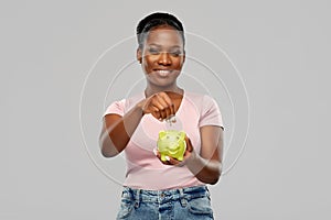 Happy african american woman with piggy bank