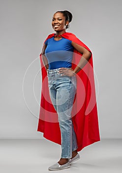 Happy african american woman in red superhero cape