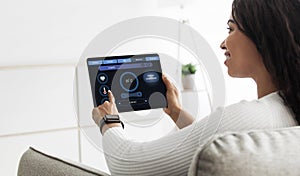 Happy african american woman regulating room temperature via smart home