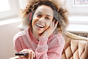 Happy african american woman smiling and listening to music with headphones