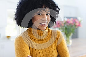 Happy african american woman standing with arms crossed at home, copy space