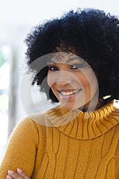 Happy african american woman standing with arms crossed at home, copy space