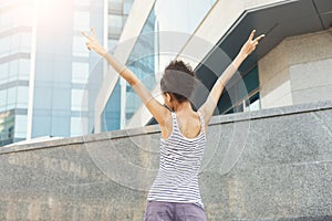 Happy black woman standing at the background of modern center photo
