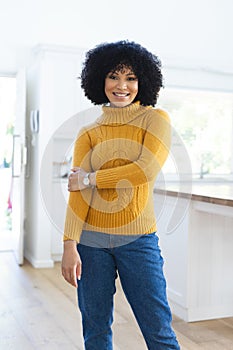 Happy african american woman standing holding hand at home, copy space