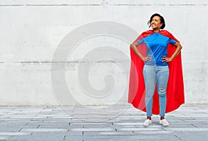 Happy african american woman in superhero red cape