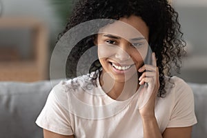 Happy african american woman talking on mobile phone at home