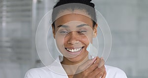 Happy african american woman using nose cleansing strip.