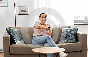 Happy african american woman watching tv at home