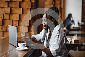 Happy african american woman worker using laptop work study at computer in loft office or cafe, smiling mixed race female student