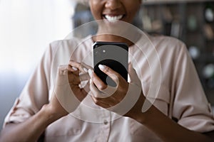 Happy African American young woman using app on mobile phone
