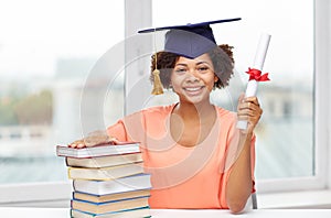 Happy african bachelor girl with books and diploma