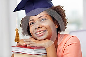 Happy african bachelor girl with books at home