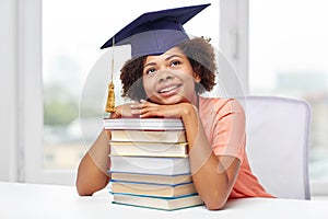 Happy african bachelor girl with books at home