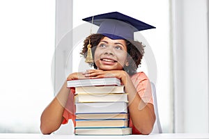 Happy african bachelor girl with books at home