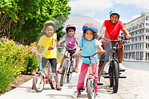 Happy African children in helmets riding bikes