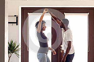 Happy african couple dancing on moving day at new house