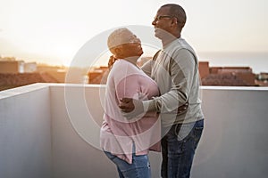 Happy african couple dancing outdoors at sunset - Soft focus on man face