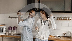 Happy African couple dancing together in modern kitchen