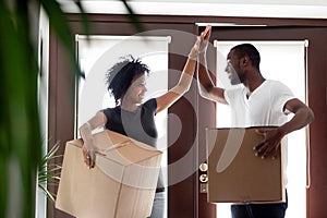 Happy african couple giving high five celebrating moving day