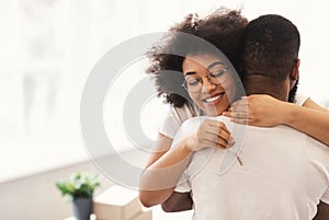 Happy African Couple Holding New House Key Embracing Standing Indoors