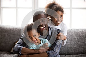 Happy african dad and mixed race children at home portrait