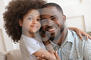 Happy african daddy and small cute child daughter embracing, portrait photo