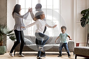Happy african family and children having fun dancing at home