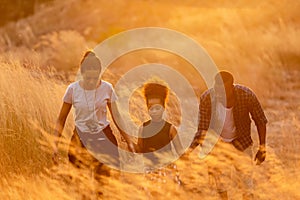Happy African family father and child daughter travel and running on meadow nature on silhouette