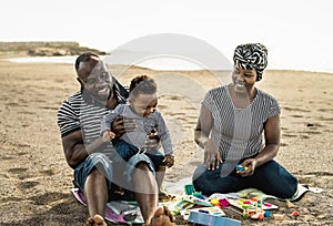 Happy African family having fun on the beach during summer holidays