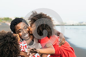 Happy African family having fun on the beach during summer holidays - Afro people enjoying vacation days