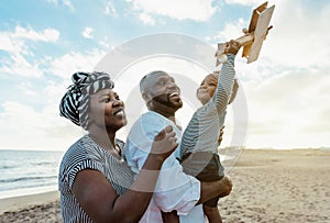 Happy African family having fun on the beach during summer vacation