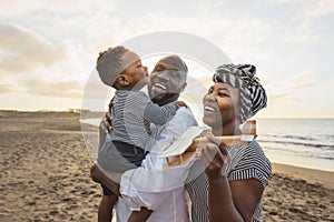 Happy African family having fun on the beach during summer vacation