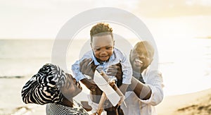 Happy African family having fun on the beach during summer vacation